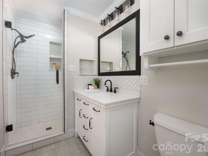 4601 General Pershing Drive, Charlotte, NC 28209.  MLS# CAR4379524, YatesRealty ID 22296. Primary bath with floor to ceiling tile and shower with storage niche