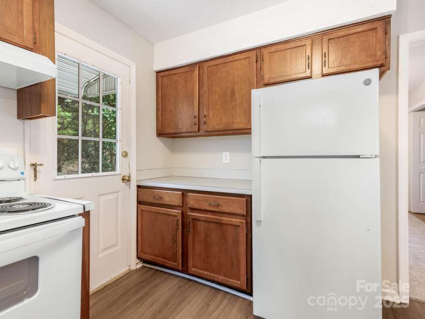 9701 Kent Village Drive, Charlotte, NC 28269.  MLS# CAR4309656, YatesRealty ID 22309. Kitchen w/new LVP, Refrigerator, Oven, and Paint
