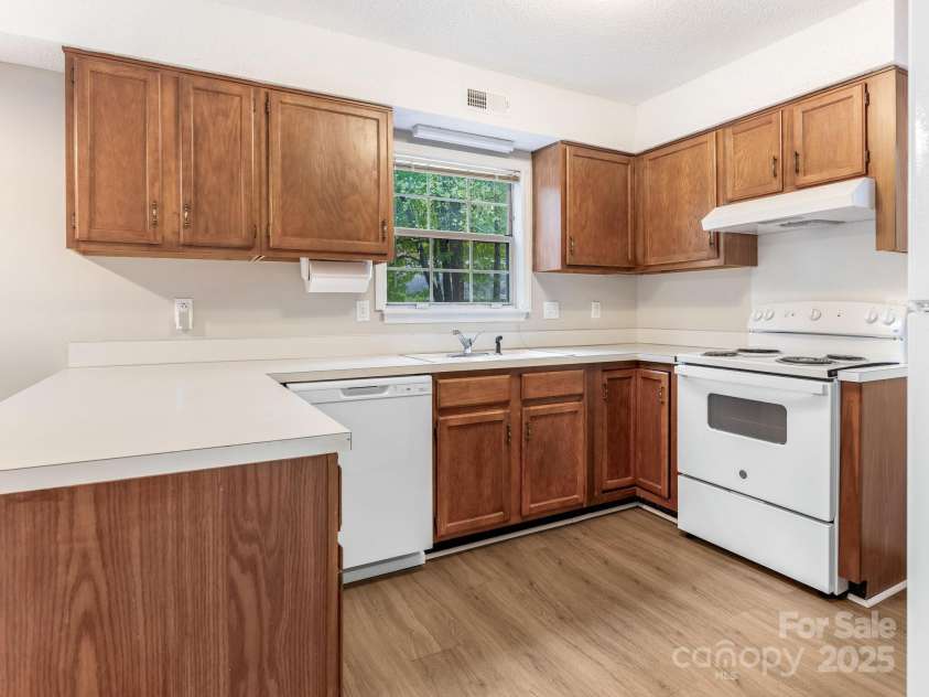 9701 Kent Village Drive, Charlotte, NC 28269.  MLS# CAR4309656, YatesRealty ID 22309. Kitchen w/new LVP, Refrigerator, Oven, and Paint