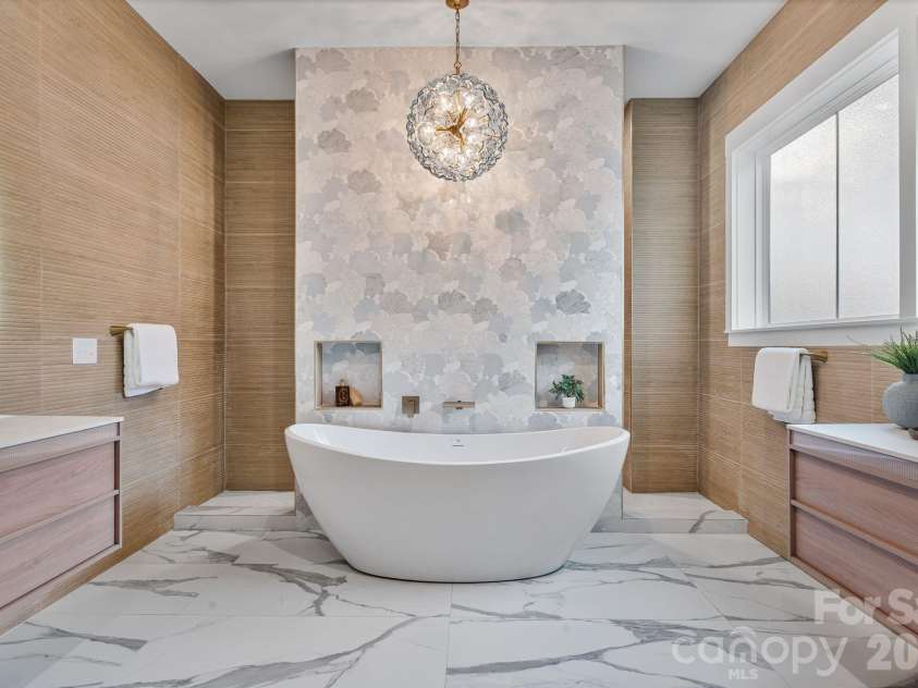 475 Canvasback Road, Mooresville, NC 28117.  MLS# CAR4366182, YatesRealty ID 22319. Stunning primary bathroom features a soaking tub centered against a custom accent wall with Walk through rain shower