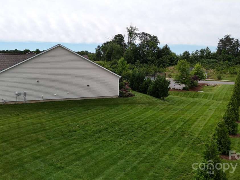 123 Hanks Bluff Drive, Mooresville, NC 28117.  MLS# CAR4258464, YatesRealty ID 22343. Green area beside home owned by HOA allowing the feel of a large yard.