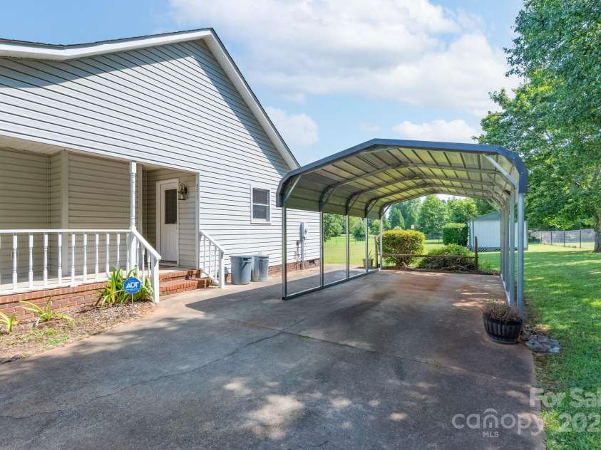 5211 Spring Glen, York, SC 29745.  MLS# CAR4270474, YatesRealty ID 22392. Side porch leading to back door into the kitchen.  Long driveway with room for multiple cars and a single carport ...