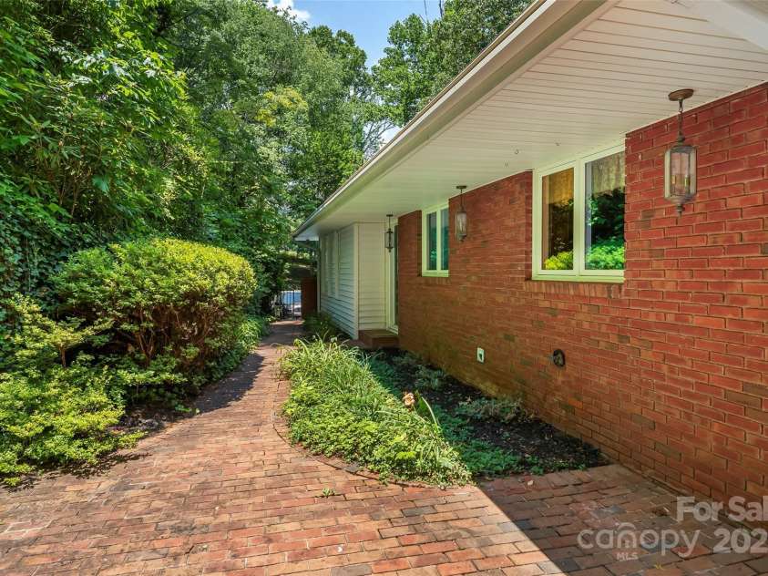 684 Woodfield Drive, Waynesville, NC 28786.  MLS# CAR4269678, YatesRealty ID 22443. Brick patio enclosed with iron gate to main driveway