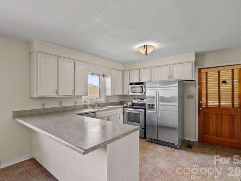 52 Will Smith Lane, Leicester, NC 28748.  MLS# CAR4379317, YatesRealty ID 22454. Door to Carport Off Kitchen
