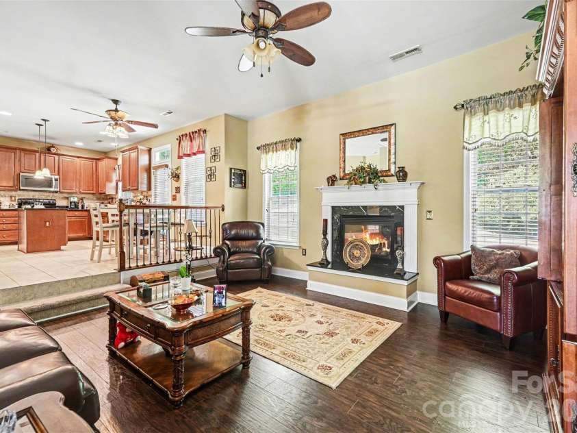 10812 Clark Street, Davidson, NC 28036.  MLS# CAR4372987, YatesRealty ID 22506. Cozy fireplace in the den that flows into the kitchen