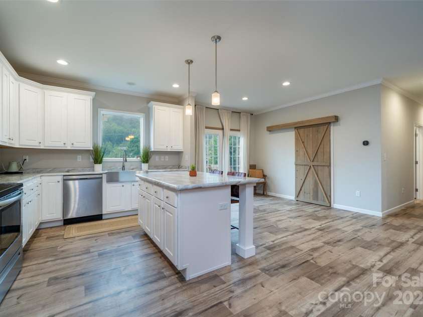306 Burnsville School Road, Burnsville, NC 28714.  MLS# CAR4261158, YatesRealty ID 22513. Large kitchen, island and dining area. This barn door opens to a huge walk in pantry.