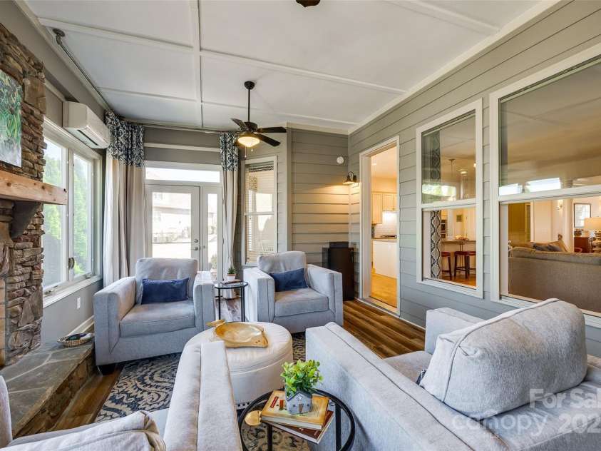 15620 Lake Ridge Road, Charlotte, NC 28278.  MLS# CAR4238155, YatesRealty ID 22515. The heart of the room is the striking stone fireplace, a focal point that adds both visual appeal and practical warmth. Its radiant heat gently spreads throughout the space, transforming the sunroom into a welcoming 
