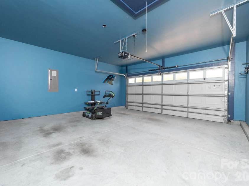 202 Paradise Hills Circle, Mooresville, NC 28115.  MLS# CAR4329082, YatesRealty ID 22528. The fully finished garage offers a clean, versatile space ready for your workbench or hobbies, with generous room for two vehicles and a thoughtfully designed nook for the gas water heater that maximizes parkin