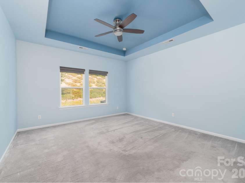 202 Paradise Hills Circle, Mooresville, NC 28115.  MLS# CAR4329082, YatesRealty ID 22528. This light-filled primary retreat features a modern box-tray ceiling with upgraded, remote-controlled ceiling fan and lighting. 