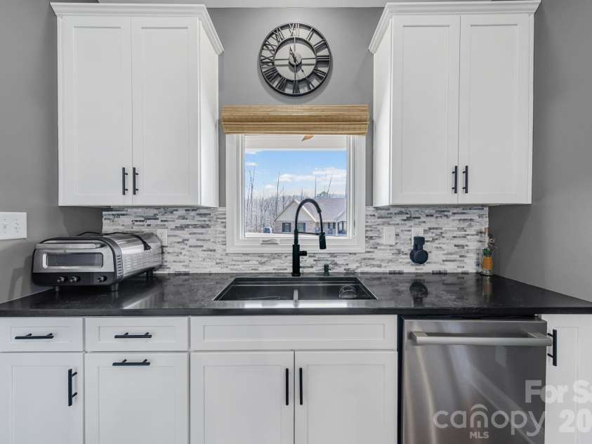 128 Laurel Ridge Drive, Statesville, NC 28677.  MLS# CAR4346436, YatesRealty ID 22532. Granite countertops, ample cabinets, stainless steel dishwasher, beautiful backsplash makes this kitchen an absolute masterpiece