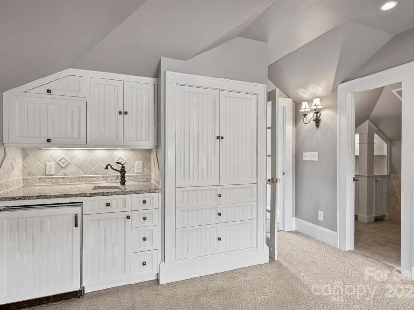 215 Main Street, Belmont, NC 28012.  MLS# CAR4134774, YatesRealty ID 22545. 3rd floor kitchenette features an under the cabinet frig, microwave,  granite countertop, sink and large pantry for storage of games and more!  Convenient half bath has lighted shelfing and pedestal sink with ceramic floors.