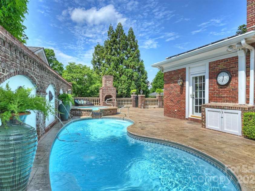 215 Main Street, Belmont, NC 28012.  MLS# CAR4134774, YatesRealty ID 22545. Built in 2008 by San Juan Pools of Charlotte,  this 16ft Kidney shaped, Salt-water pool with 8 ft spa is gas heated.  The Primary bath is conveniently accessed by the French door shown.  The built-in brick cabinet is perfect