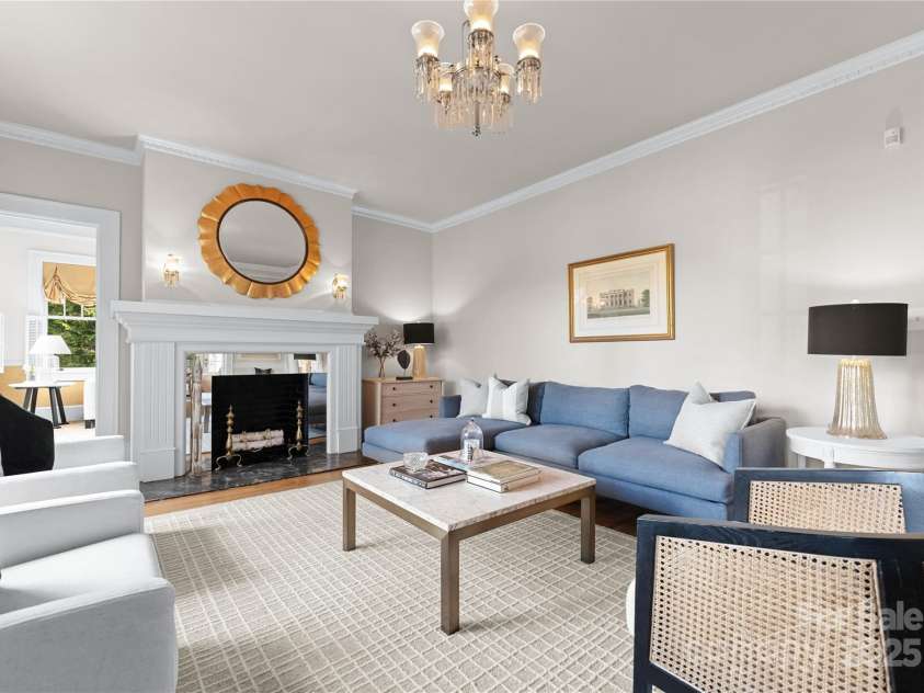 215 Main Street, Belmont, NC 28012.  MLS# CAR4134774, YatesRealty ID 22545. Living room has large Ionic vintage wood columns that match the exterior columns.  The gracious staircase beyond is in the 2nd foyer.  Fireplace features a French antique mirror glass surround and faux marble hearth. Home ha