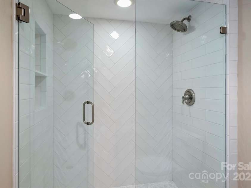 215 Main Street, Belmont, NC 28012.  MLS# CAR4134774, YatesRealty ID 22545. New shower installed in 2024!  Beautiful oversize tile in herringbone pattern, new oversized shower head and river  floor.