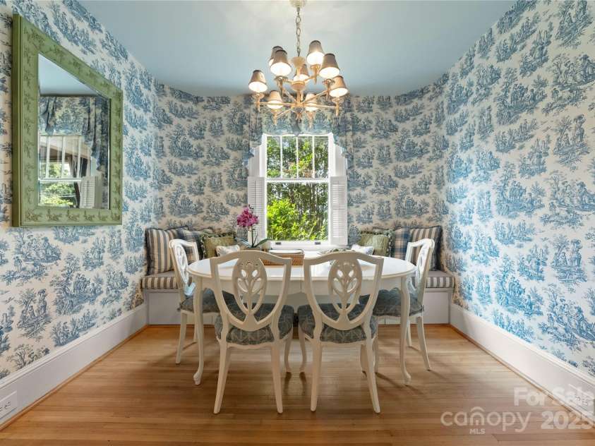 215 Main Street, Belmont, NC 28012.  MLS# CAR4134774, YatesRealty ID 22545. The Breakfast room has classic blue and white toile wall paper with matching drapes.  The oversize bench has matching cushions and pillows.  The bench has pull out drawers and center lifts up for lots of storage.  This sunny