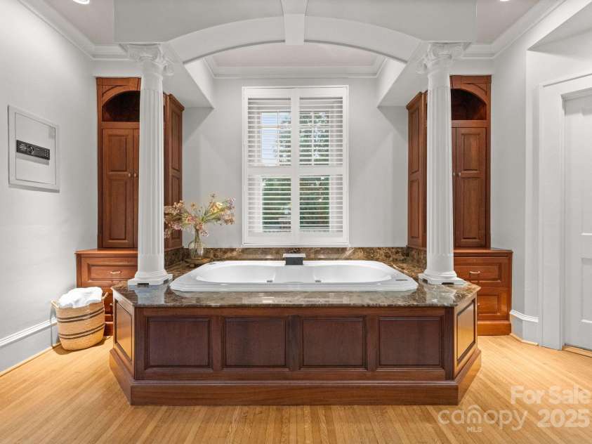 215 Main Street, Belmont, NC 28012.  MLS# CAR4134774, YatesRealty ID 22545. The primary bathroom is very large and features gorgeous mahogany handmade cabinetry.  The Jacuzzi tub is lighted with jets, continuous rapid heating, waterfall faucet and spacious marble tub surround.  Double Walnut linen c