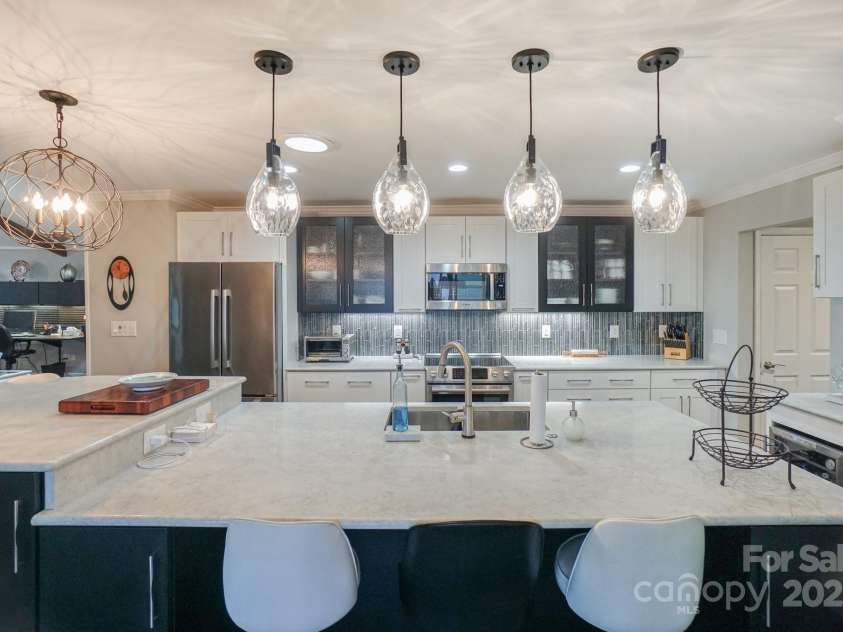 7945 Placid Court, Denver, NC 28037.  MLS# CAR4269290, YatesRealty ID 22561. Notice the attention to detail with the rain glass cabinetry front and tiled backsplash, all as your guests sit and talk to you from the large island while preparing in the kitchen.