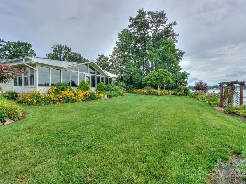 7945 Placid Court, Denver, NC 28037.  MLS# CAR4269290, YatesRealty ID 22561. Right side of backyard looking north, again showing original pergola and lush landscaping.