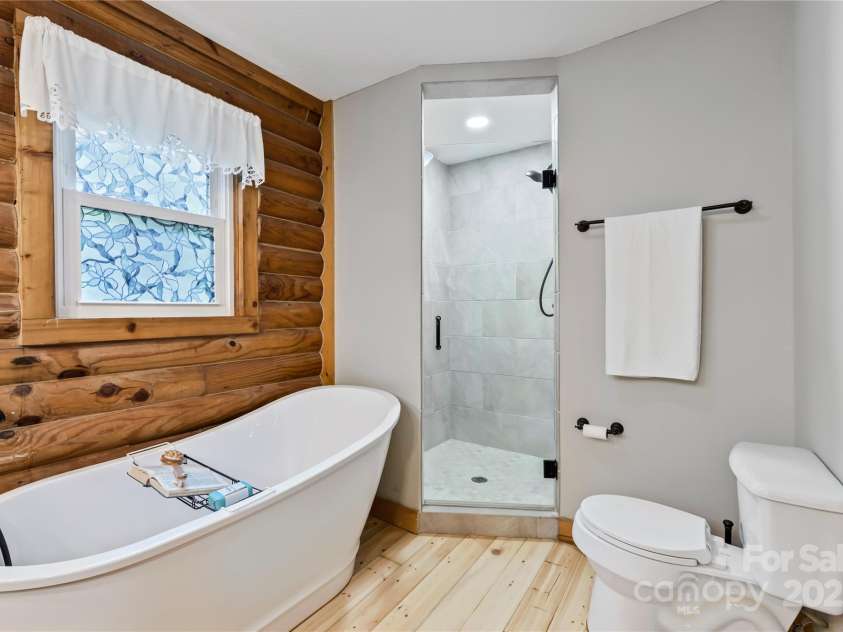 6836 Summer Hill Drive, Denver, NC 28037.  MLS# CAR4271136, YatesRealty ID 22574. Indulge in a spa-like retreat with a freestanding tub and sleek custom tile shower in the luxurious primary bath.