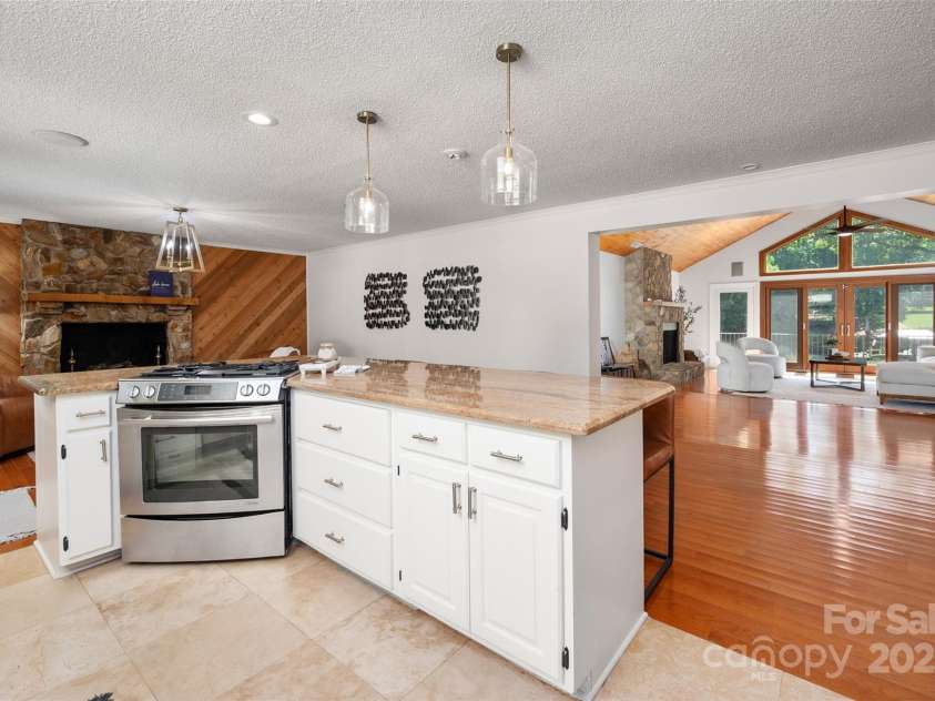 6259 River Cabin Lane, Charlotte, NC 28278.  MLS# CAR4271955, YatesRealty ID 22576. The open-concept kitchen with large island flows into a vaulted family room w/ stunning lake views & custom fireplace w/ new gas logs