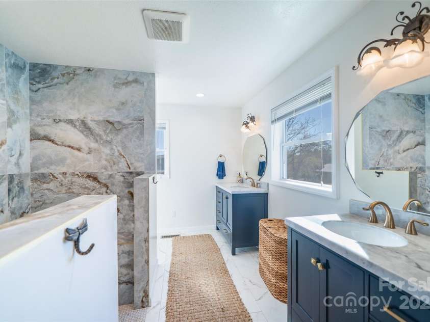 39 Pershing Road, Asheville, NC 28805.  MLS# CAR4321387, YatesRealty ID 22596. Separate dual vanities and a window in the bathroom.