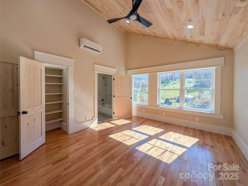 7854 US Highway 19E None, Burnsville, NC 28714.  MLS# CAR4319007, YatesRealty ID 2260. First bedroom to right offers vaulted tongue & groove ceiling, recessed lighting, ceiling fan, large insulated pela windows showcasing mountain views, closet with built-in shelving, large walk-in closet and access
