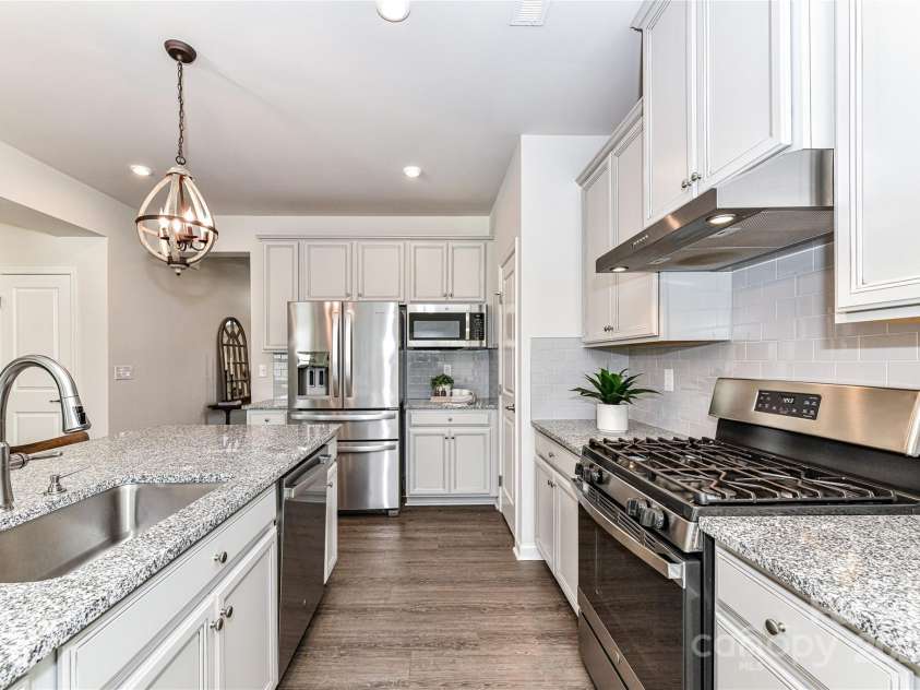 3180 Streamside Drive, Davidson, NC 28036.  MLS# CAR4230634, YatesRealty ID 2264. Upgraded Kitchen features granite counters, stainless steel appliances, gas range, island, tile back splash, upgraded lighting, pantry & breakfast area!