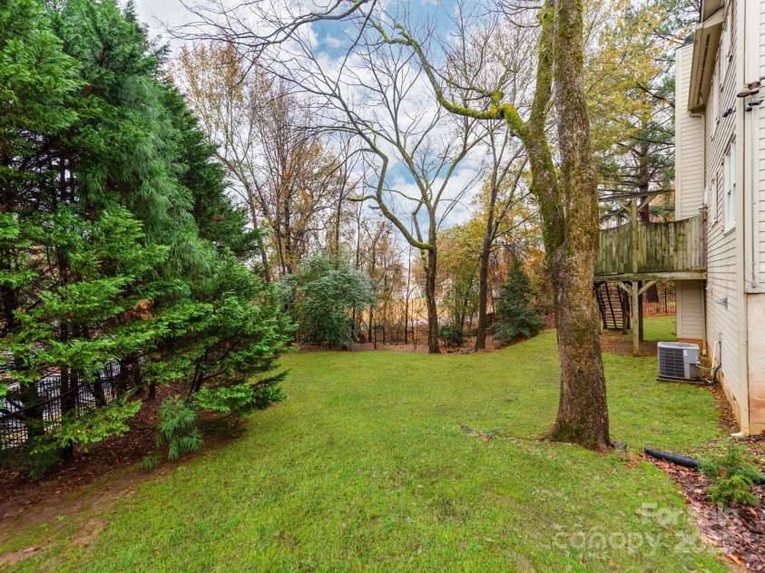 501 River Oaks Lane, Charlotte, NC 28226.  MLS# CAR4192085, YatesRealty ID 22698. The outdoor space is surrounded by lush landscaping, creating a serene and picturesque environment. Vibrant greenery, thoughtfully placed flowers, and well-maintained shrubs enhance the natural beauty of the area, prov
