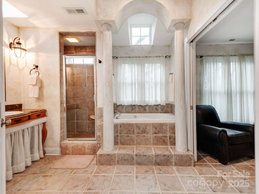 501 River Oaks Lane, Charlotte, NC 28226.  MLS# CAR4192085, YatesRealty ID 22698. The owner’s suite is a luxurious retreat, complete with a private bath and an exclusive dressing area. The en-suite bath offers spa-like comfort, featuring elegant fixtures and a serene ambiance. The dedicated dressing