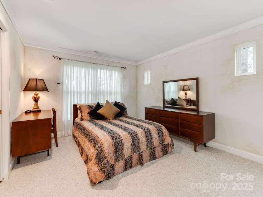 501 River Oaks Lane, Charlotte, NC 28226.  MLS# CAR4192085, YatesRealty ID 22698. The upstairs bedroom showcases its spacious layout and thoughtful design. The elevated view overlooking the downstairs living area highlights the room’s connection to the home while maintaining its private charm. With 