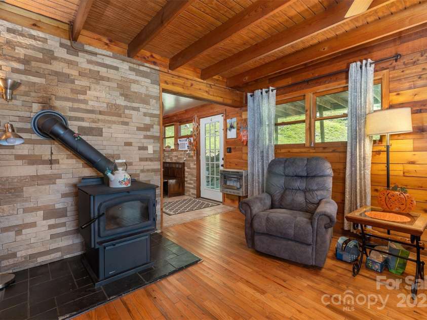 1145 Woolyshot Branch Road, Hot Springs, NC 28743.  MLS# CAR4295648, YatesRealty ID 227. Wood burning stove in living room. 