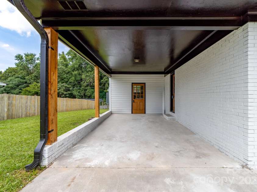 2610 Fairgreen Drive, Gastonia, NC 28056.  MLS# CAR4273614, YatesRealty ID 22701. Carport - Backside of carport leads to laundry. The door on the back right leads to living room / dining area