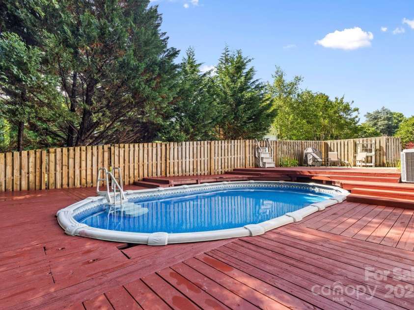 131 Canopy Court, Mooresville, NC 28115.  MLS# CAR4268984, YatesRealty ID 22713. Above-ground pool fully wrapped in decking—your summer oasis awaits.