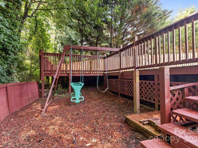 131 Canopy Court, Mooresville, NC 28115.  MLS# CAR4268984, YatesRealty ID 22713. Lower-level play space with swing set tucked under deck—charming and fun!