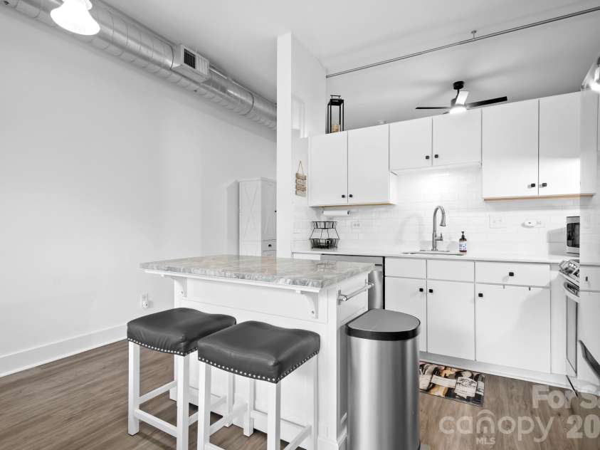 1611 Central Avenue, Charlotte, NC 28205.  MLS# CAR4378247, YatesRealty ID 22730. Kitchen island with 2 barstools perfect for a quick bite or entertaining! Extra Counterspace for meal prep too! Stocked kitchen with items will convey as -is. TURN KEY!