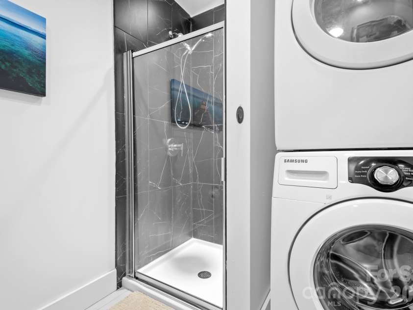 1611 Central Avenue, Charlotte, NC 28205.  MLS# CAR4378247, YatesRealty ID 22730. Standing shower and stacked washer dryer. Updated in 2024
