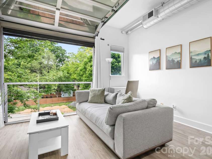 1611 Central Avenue, Charlotte, NC 28205.  MLS# CAR4378247, YatesRealty ID 22730. Super Cool Garage Door Window for Open Air Loft Feeling! 1 Bedroom Condo with Open Floorplan, ELEVATOR ACCESS, Covered and Uncovered parking! Unit on backside of building for quiet enjoyment. Overlooks Trees, Parking A
