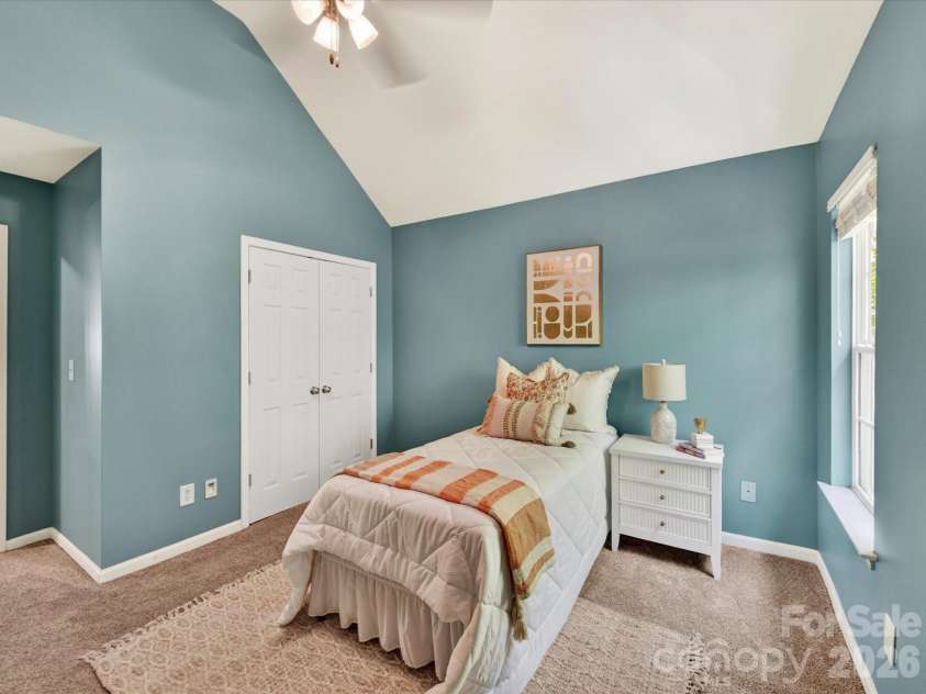 19040 Oakhurst Boulevard, Cornelius, NC 28031.  MLS# CAR4373641, YatesRealty ID 22748. Bright and inviting secondary bedroom with vaulted ceilings, soft natural light, and a comfortable layout ideal for guests, family, or a home office.