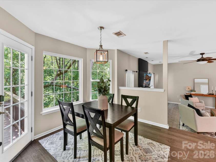 19040 Oakhurst Boulevard, Cornelius, NC 28031.  MLS# CAR4373641, YatesRealty ID 22748. Bright breakfast nook with large windows, a cozy dining area, and direct access to the deck—perfect for enjoying morning coffee with serene, tree-lined views.