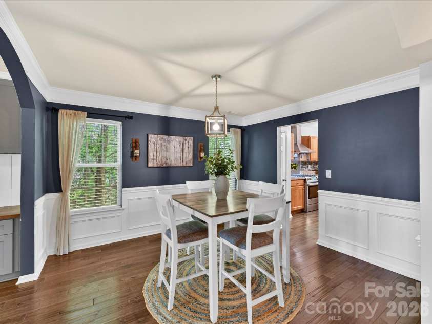 19040 Oakhurst Boulevard, Cornelius, NC 28031.  MLS# CAR4373641, YatesRealty ID 22748. Elegant dining room with classic wainscoting, rich accent walls, and abundant natural light, offering a warm and inviting space for gatherings.