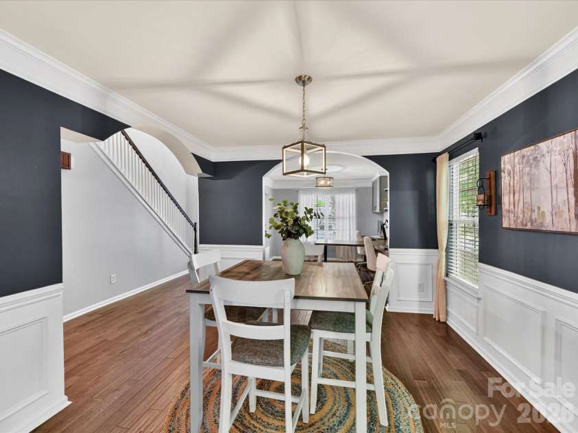 19040 Oakhurst Boulevard, Cornelius, NC 28031.  MLS# CAR4373641, YatesRealty ID 22748. Elegant dining room with classic wainscoting, rich accent walls, and abundant natural light, offering a warm and inviting space for gatherings.