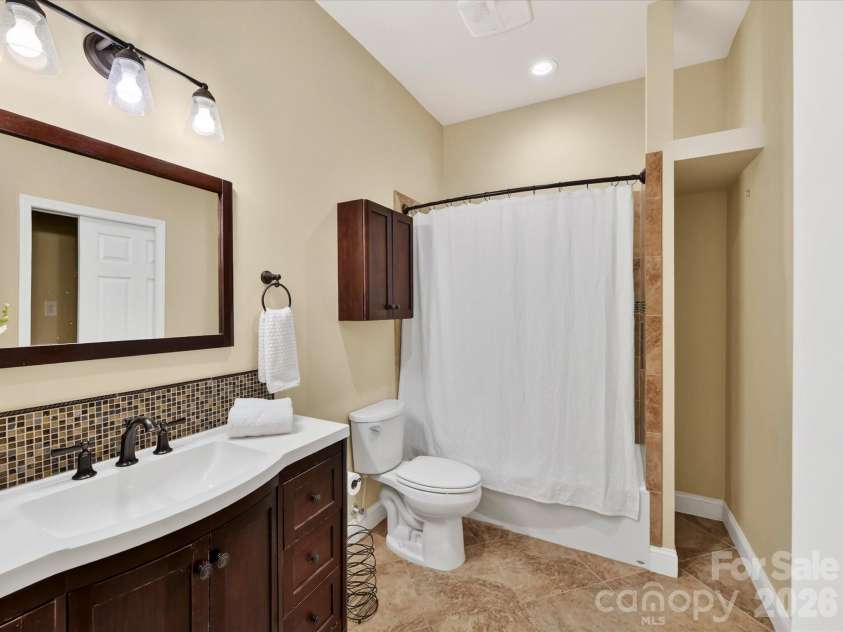19040 Oakhurst Boulevard, Cornelius, NC 28031.  MLS# CAR4373641, YatesRealty ID 22748. Full bath featuring a sleek vanity with mosaic backsplash, updated lighting, and a tub/shower combo for everyday convenience.