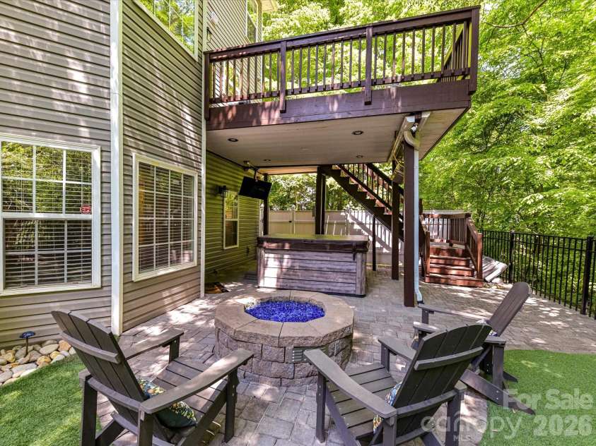 19040 Oakhurst Boulevard, Cornelius, NC 28031.  MLS# CAR4373641, YatesRealty ID 22748. Inviting patio with a custom fire pit and seating area, overlooking a private, fenced yard with lush greenery for the perfect outdoor retreat.