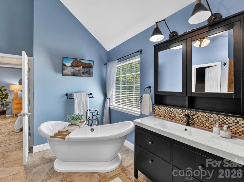 19040 Oakhurst Boulevard, Cornelius, NC 28031.  MLS# CAR4373641, YatesRealty ID 22748. Spa-like primary bath featuring a freestanding soaking tub, custom tiled walk-in shower, and dual vanity with stylish finishes throughout.