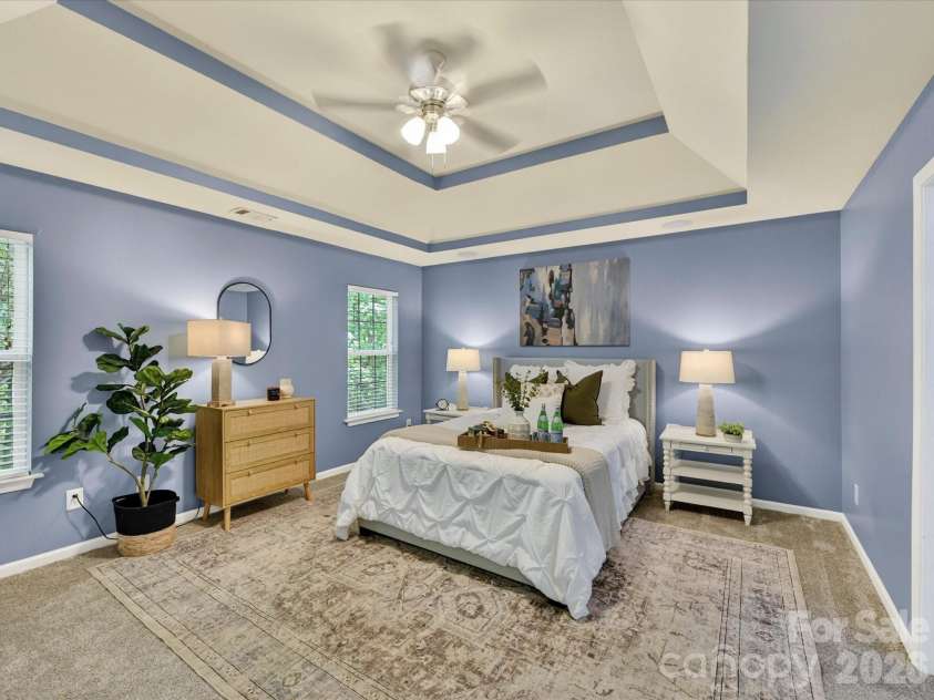 19040 Oakhurst Boulevard, Cornelius, NC 28031.  MLS# CAR4373641, YatesRealty ID 22748. Spacious primary suite featuring a tray ceiling, generous layout with sitting area, and abundant natural light, creating a relaxing private retreat.