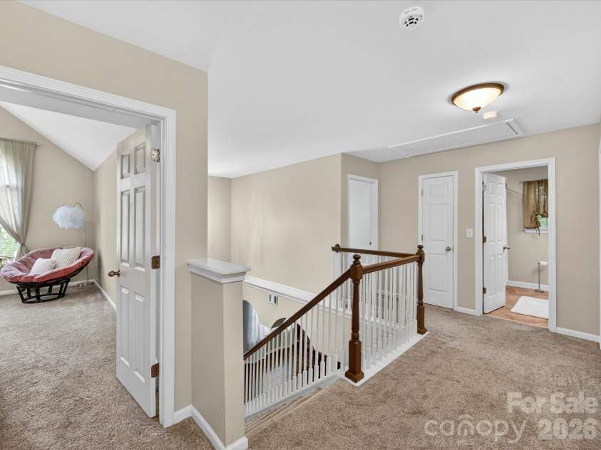 19040 Oakhurst Boulevard, Cornelius, NC 28031.  MLS# CAR4373641, YatesRealty ID 22748. Spacious upper-level landing with plush carpeting and open railing, offering a bright and versatile area connecting the home’s bedrooms and baths.