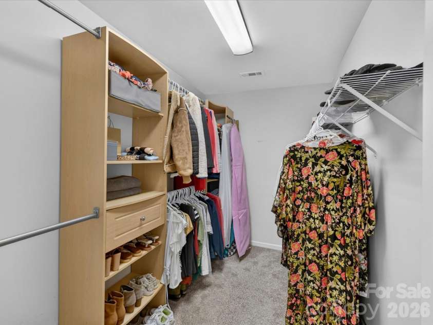 19040 Oakhurst Boulevard, Cornelius, NC 28031.  MLS# CAR4373641, YatesRealty ID 22748. Spacious walk-in closet with built-in shelving and ample hanging space, offering organized and functional storage for the primary suite.