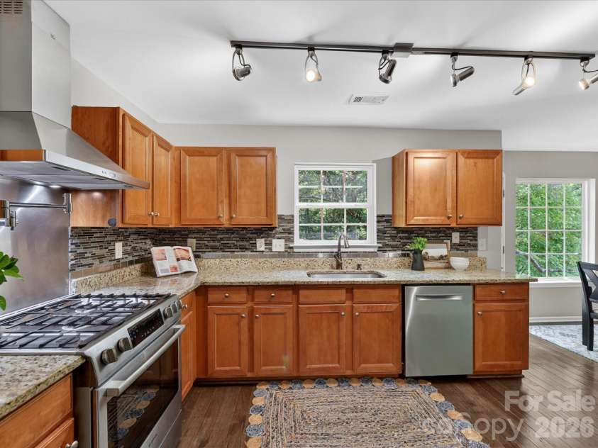 19040 Oakhurst Boulevard, Cornelius, NC 28031.  MLS# CAR4373641, YatesRealty ID 22748. Updated kitchen featuring granite countertops, stainless steel appliances, custom tile backsplash, and ample cabinetry, all highlighted by abundant natural light.