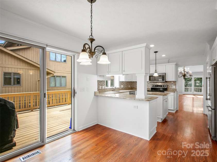 205 Wild Oak Lane, Hendersonville, NC 28791.  MLS# CAR4240419, YatesRealty ID 22765. Breakfast area off kitchen. Sliding door opens to one of three decks with natural gas grill that is grandfathered in.