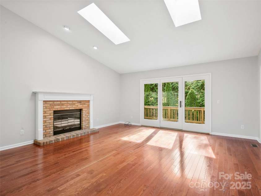 205 Wild Oak Lane, Hendersonville, NC 28791.  MLS# CAR4240419, YatesRealty ID 22765. Living Room with gas fireplace.  Opens to one of three decks. Natural area behind, no visible homes.